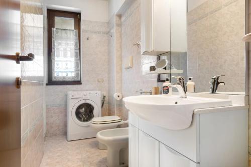 a white bathroom with a sink and a washing machine at Residence San Zeno S P House in Bardolino