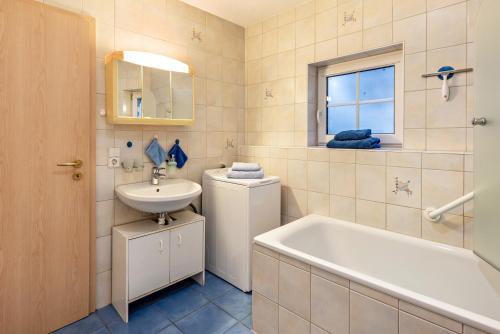 y baño con lavamanos, bañera y lavamanos. en Ferienwohnung Alexandra en Rheinfelden