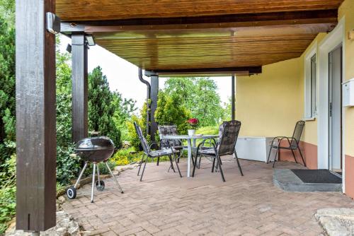 a patio with a table and chairs and a grill at Ferienwohnung Alexandra in Rheinfelden