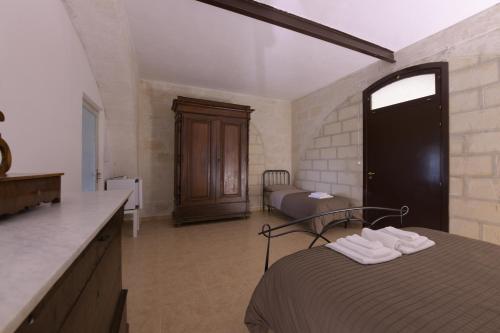 a bedroom with a bed and a bathroom with a sink at Agriturismo Masseria Santa Lucia al Bradano in Matera