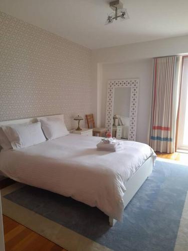 Un dormitorio con una gran cama blanca y una ventana en Casa da Ria Barra, Free garage, en Gafanha da Nazaré