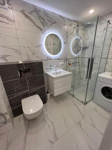 a bathroom with a toilet and a sink and a shower at Vanilės home in Šiauliai