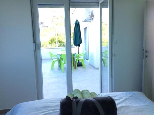 a bed with a bag on it with a view of a patio at Lapčiči View in Budva