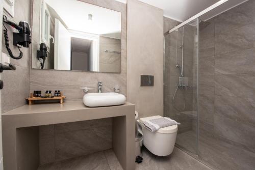 a bathroom with a toilet and a sink and a shower at Blue Bay Resort Village in Batsi