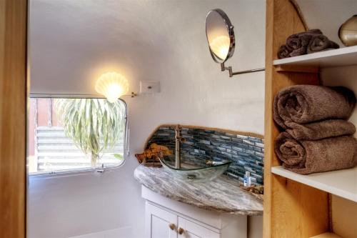 uma casa de banho com lavatório, espelho e toalhas em Cowabunga By Pacific Blue em Fort Bragg