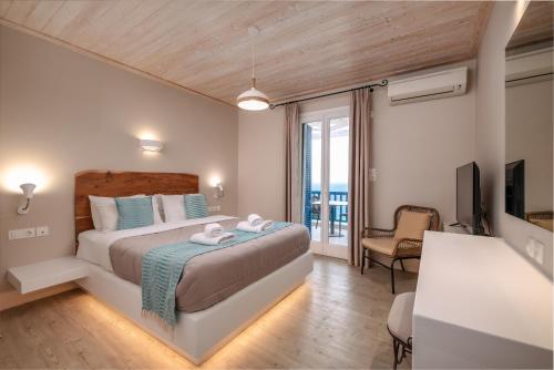 a bedroom with a large bed and a balcony at Blue Bay Resort Village in Batsi