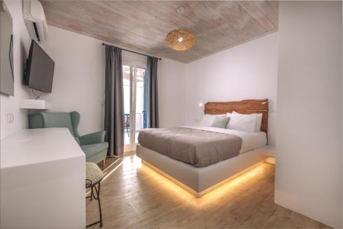 a bedroom with a bed and a couch and a tv at Blue Bay Resort Village in Batsi