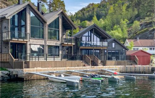 a house on the water with boats in the water at 3 Bedroom Lovely Home In Hebnes in Hebnes