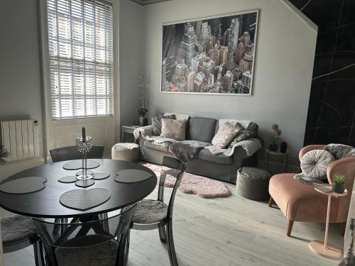a living room with a table and a couch at Courtyard Holiday Apartments in Belper