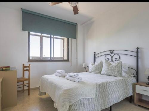 a white bedroom with a bed with towels on it at Cañailla in San Fernando