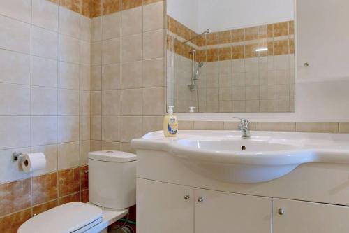 a bathroom with a sink and a toilet and a mirror at Poulades Villa, Corfu in Danilia