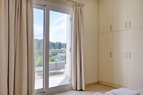 a bedroom with a large glass door to a balcony at Poulades Villa, Corfu in Danilia