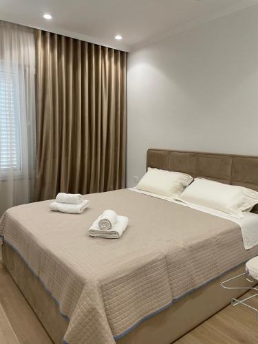 ein Schlafzimmer mit einem großen Bett mit Handtüchern darauf in der Unterkunft City Center Apartment Kafe Flora in Tirana
