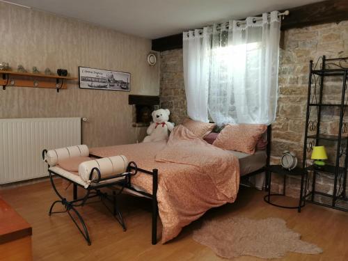 a bedroom with a teddy bear sitting on a bed at La roche Saint roch in Grusse