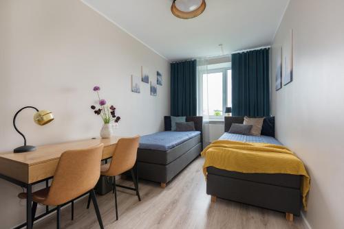 een slaapkamer met een bureau, een bed en een tafel bij Kalevi City Center Apartment in Tartu