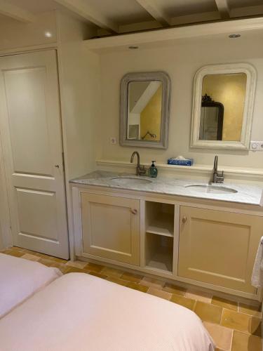 La salle de bains est pourvue de 2 lavabos et de 2 miroirs. dans l'établissement Cottage Het Beukenootje, à Aerdenhout