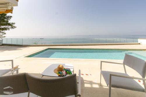 une table avec un ours en peluche à côté d'une piscine dans l'établissement Vista Roses Mar - El Brancs, à Roses