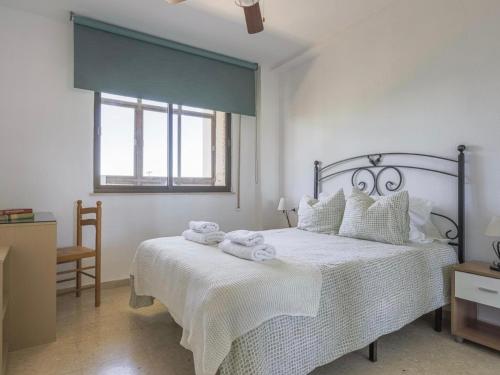 a white bedroom with a bed with towels on it at Cañailla in San Fernando