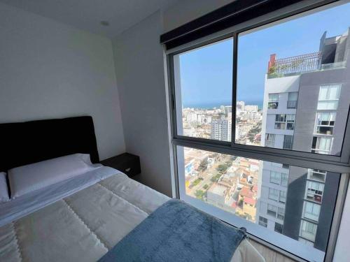 a bedroom with a bed and a large window at Luxury Apartment in Magdalena 2BR limit San Isidro in Lima