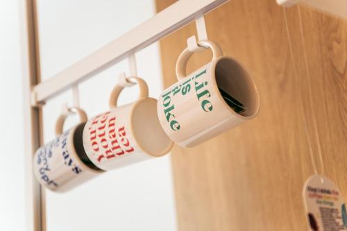 a group of coffee cups hanging from a rack at Hotel Kitchen59 in Sofia