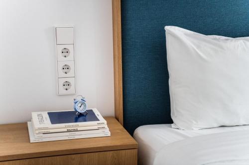 a alarm clock sitting on a night stand next to a bed at Hotel Kitchen59 in Sofia