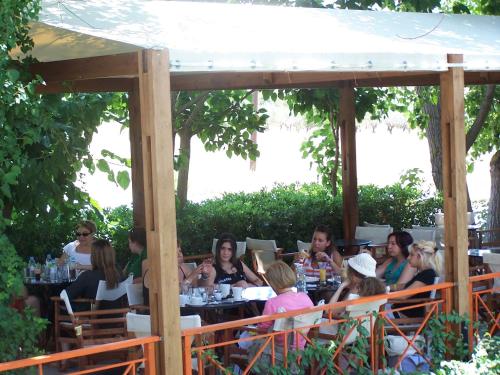 people sitting around a picnic table at Avaton Hotel in Lygourio