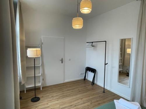 a room with white walls and a mirror and a lamp at LUCKY STAYS LS07 - Vollausstattung - Zentrum - Aufzug - große Küche - 2 Zimmer - Smart-TV in Magdeburg