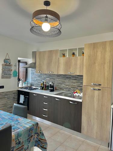 a kitchen with wooden cabinets and a sink at Xenia House in Lascari