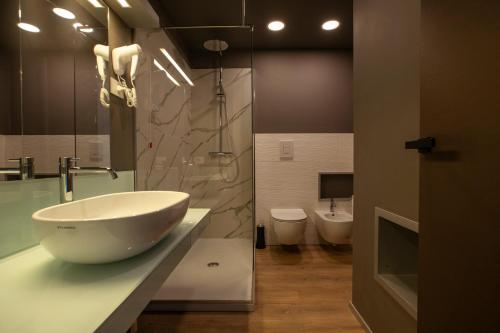 a bathroom with a large bowl sink and a toilet at Hotel Belvedere Resort in Castellammare del Golfo