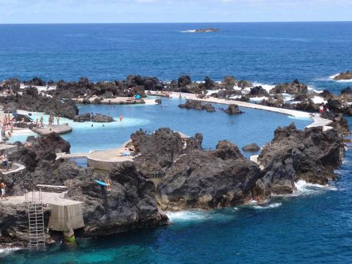 a group of water slides in the ocean with rocks at Madeira Bright Star by Petit Hotels in Funchal