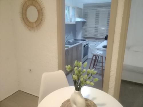 un vaso bianco con fiori su un tavolo in cucina di President Guest House a Keratokampos