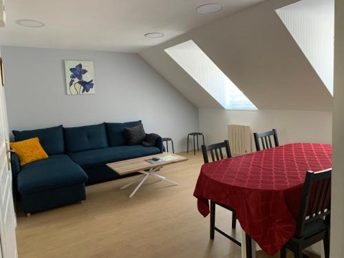 - un salon avec un canapé bleu et une table dans l'établissement Le Val Fleuri, à La Bourboule