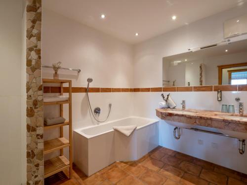 a bathroom with a large tub and a sink at jezz AlmResort Ellmau in Ellmau