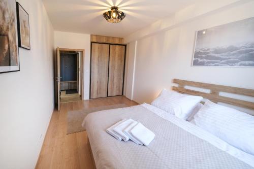 a bedroom with a white bed with two towels on it at Apartmán Pod svahem in Loučná pod Klínovcem