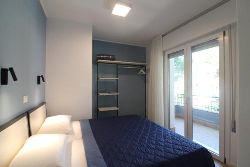 リニャーノ・サッビアドーロにあるAppartamento Venereのベッドルーム(青いベッド1台、窓付)