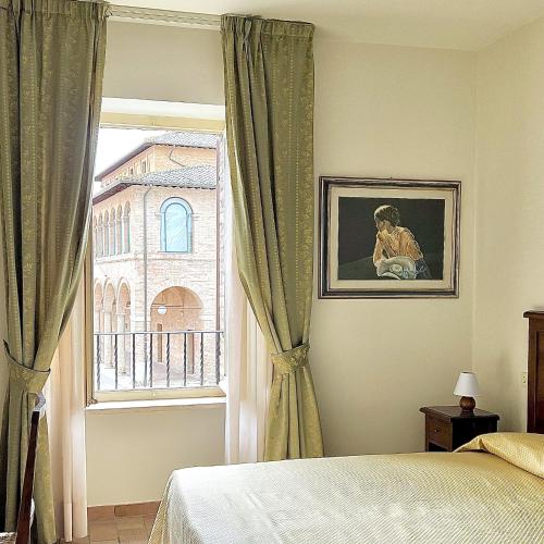 een slaapkamer met een bed en een raam bij Biagetti Bedrooms Affittacamere in Santa Maria degli Angeli