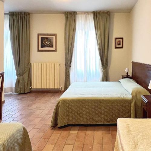 a bedroom with two beds and a large window at Biagetti Bedrooms Affittacamere in Santa Maria degli Angeli