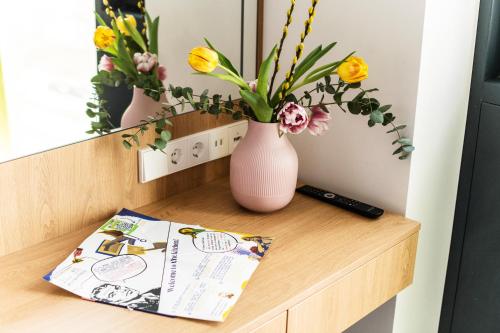 a book on a table with flowers in a vase at Hotel Kitchen59 in Sofia