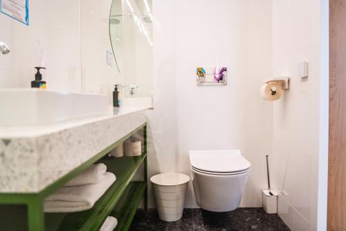 a white bathroom with a sink and a toilet at Hotel Kitchen59 in Sofia