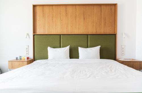 a bed with a green headboard and two white pillows at Hotel Kitchen59 in Sofia