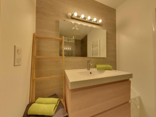 ein Badezimmer mit Waschbecken und Spiegel in der Unterkunft La Bourboule Centre - Magnifique T3 avec Balcon, Wi-Fi, Animaux Acceptés - FR-1-608-119 in La Bourboule