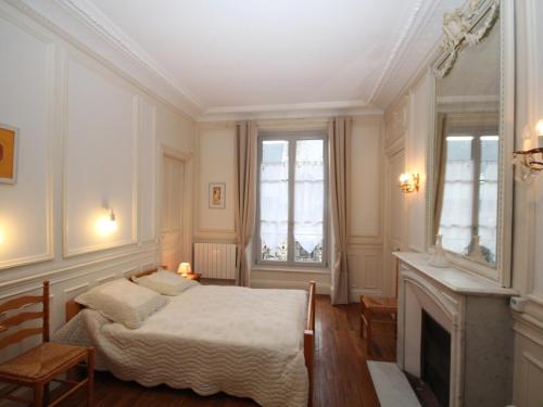 une chambre avec un lit et une cheminée dans l'établissement CENTRE MONT-DORE - BEL APPARTEMENT T2 + MEZZANINE - FR-1-608-149, à Le Mont-Dore