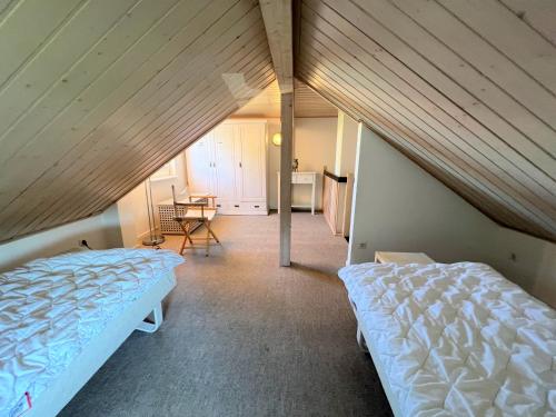 a attic bedroom with two beds and a table at Strandpark Sierksdorf H054 in Sierksdorf