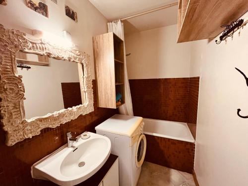 y baño con lavabo, aseo y espejo. en Appartement du marin art & océan, en Saint-Jean-de-Monts