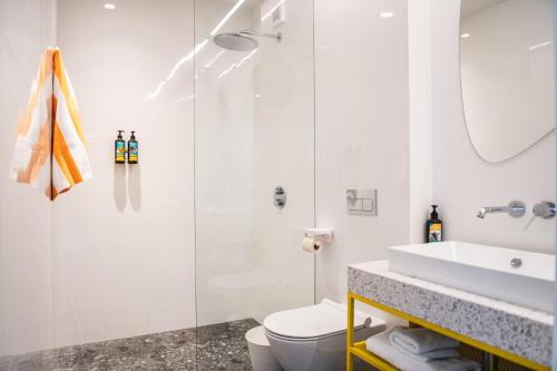 a bathroom with a shower and a toilet and a sink at Hotel Kitchen59 in Sofia