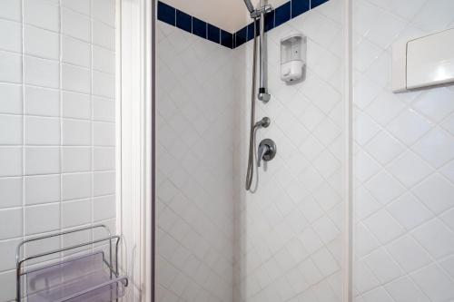 a shower in a bathroom with blue and white tiles at Castelmola Casa Chiocciola with Terraces in Castelmola