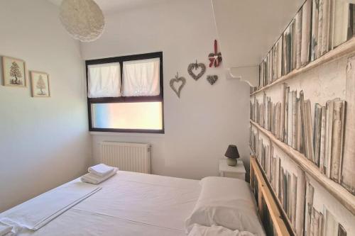 a bedroom with a bed and a shelf with books at VOLTA Pool&Beach apartment in Bardolino