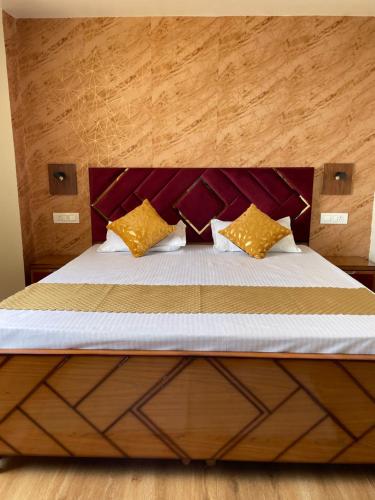 a bed with yellow pillows on top of it at Aammk homes in Shimla
