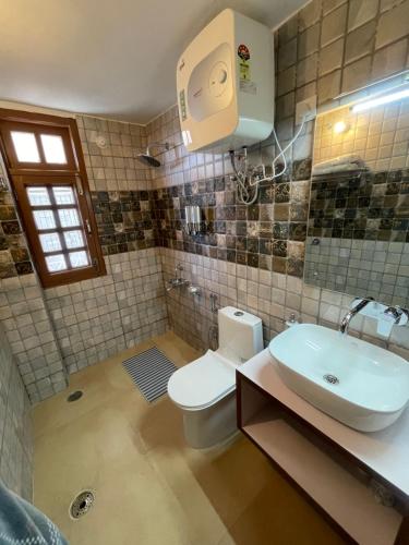 a bathroom with a white toilet and a sink at Aammk homes in Shimla
