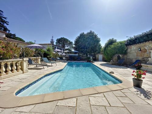 a swimming pool in a yard with a patio at Les villas du Golf Mougins in Mougins